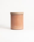 A pink soy wax candle with a lid, labeled 'FIELD KIT'.