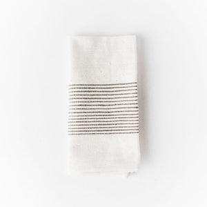 White cotton napkin with black stripes on a white background