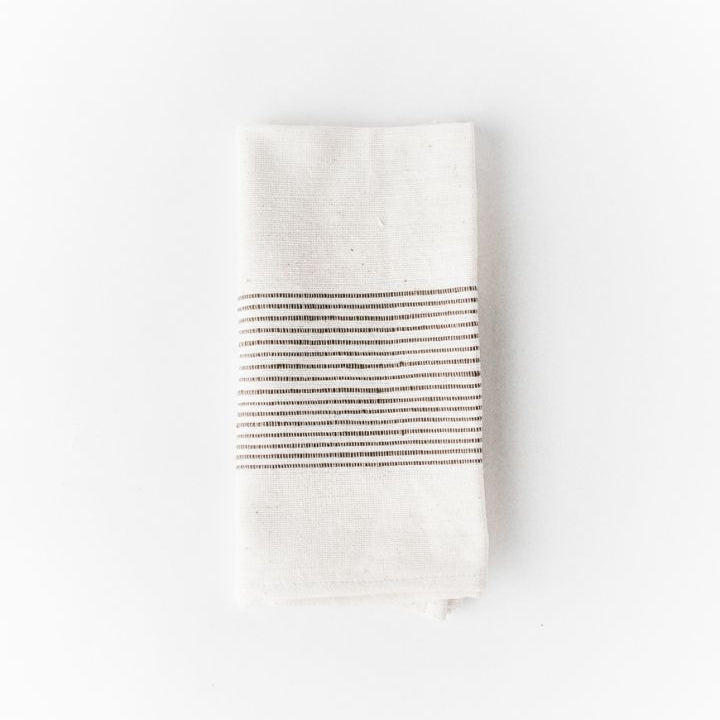 White cotton napkin with black stripes on a white background